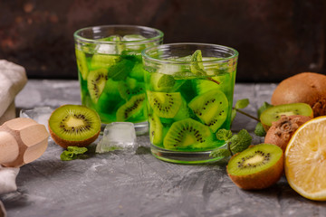 Cocktail with kiwi and mint in a glass on a wooden background. Selective focus. Homemade lemonade with kiwi