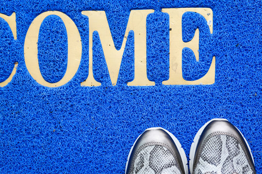 A Pair Of Trainers On Blue Welcome Mat Texture Background.