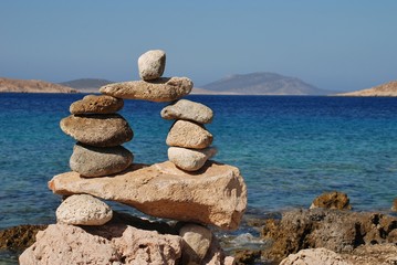 Fototapeta na wymiar A tower of stones on Ftenagia beach at Emborio on the Greek island of Halki.