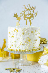Golden birthday concept - cake, presents, decorations