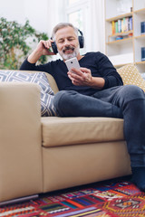 Middle-aged man in headphones at home