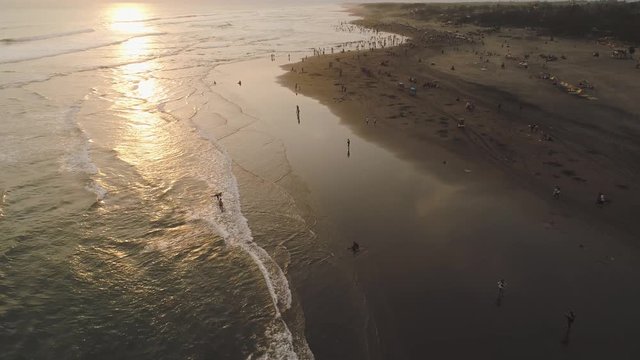 sandy beach parangtritis near ocean with big waves, people in tropical resort at sunset. Yogyakarta, Indonesia. aerial view seascape, ocean and beautiful beach. Travel concept. Indonesia, jawa