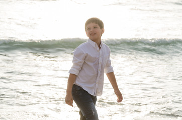 Fototapeta na wymiar Portrait of a happy little boy playing on the beach in summer