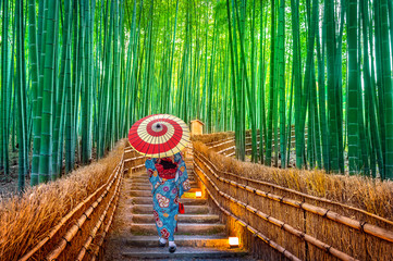 Obraz premium Las bambusowy. Azjatycka kobieta ubrana w tradycyjne japońskie kimono w Bamboo Forest w Kioto, Japonia.