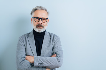 Serious man with folded arms staring at the camera