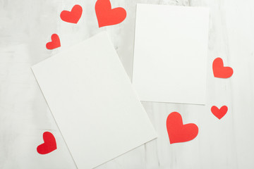 Valentine background with red hearts and white postcard for design on a white background. Happy baby day card mock up, copy space.Flat-lay