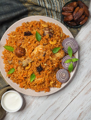 Homemade chicken Biryani served with yogurt dip and dates. Arabian food. 