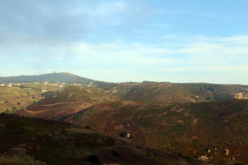 Fog and clouds arriving to sunny landscape