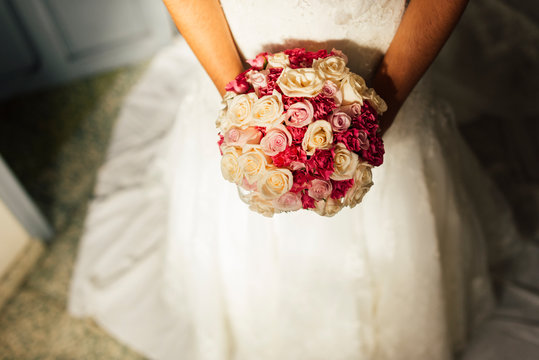 Bride holding bridal bouquet with fresh pink roses