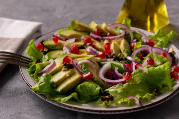 Healthy salad with avocado, pomegranate seeds and walnuts.