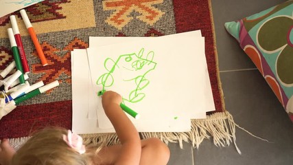 Little girl drawing on paper. Top view