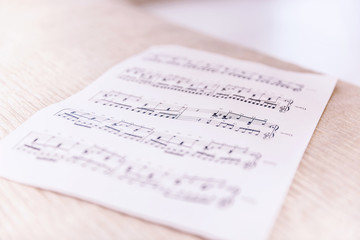 Closeup sheet with musical notes lying on the bed