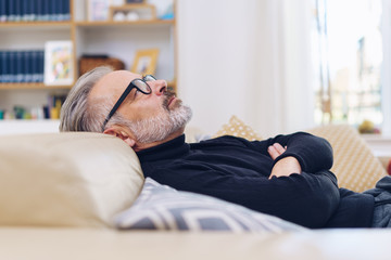 Middle-aged man relaxing on a sofa at home