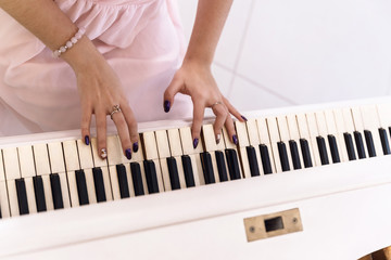 Closeup of female hands playing piano keys