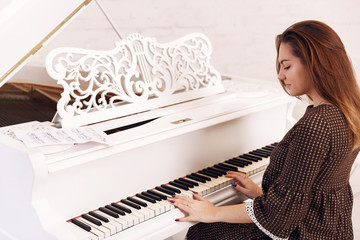 Smilling young woman playing the piano