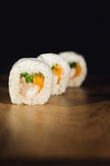 Closeup of three white sushi rolls on black