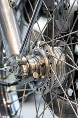 Obraz premium Engineered motorcycle wheel parts. Disc brake suspension and spokes. Complex engineering close-up.