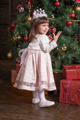 Little cute girl near Christmas tree.