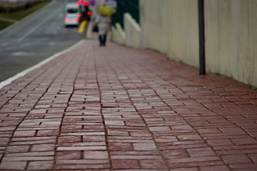 Drops of rain close-up on the sidewalk tile of the pedestrian road. downpour, bad weather