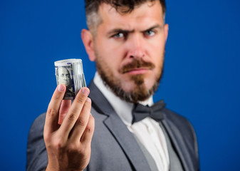 Man bearded hipster hold rolled dollars banknotes. Guy formal suit offer bribe or purchase. Hipster...
