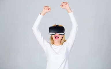 Excited smiling businesswoman wearing virtual reality glasses. Portrait of woman in white blouse with virtual reality glasses on head isolated on grey background. Woman excited using 3d goggles.
