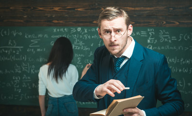 Teacher man using glasses scared in shock, expressing panic and fear at classroom