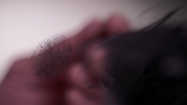 ECU MACRO SHOT OF FINGERINTS BEING DUSTED ON GLASS.  IN 4K, 10 BIT, 4:2:2.