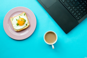 breakfast and laptop on blue background.