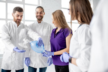 Group of medics standing together with breathing tool during the first aid training indoors