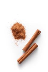 Cinnamon sticks and grounded cinnamon isolated on a white background. Cinnamon spice powder viewed from above. Top view.