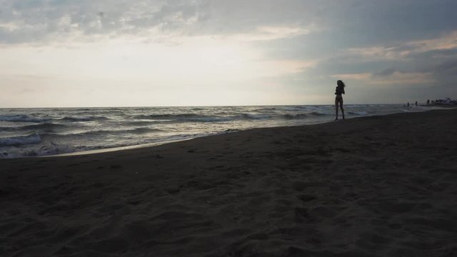 Girl runs on the beach at sunset. Sport, fitness.