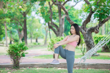 Naklejka premium Asian sporty woman stretching body breathing fresh air in the park,Thailand people,Fitness and exercise concept