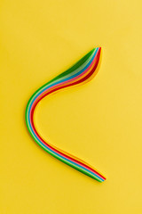 Colored paper strips for quilling. Quilling blank. Cardboard concept for homemade cards. The art of quilling on a yellow background. Portrait orientation.