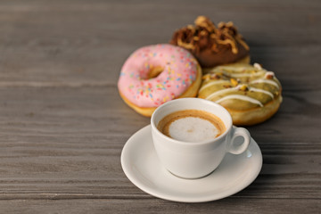 Cup of coffee and doughnuts, shallow depth of field.