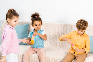 cute multiethnic children playing with soap bubbles together
