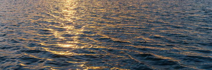 Water waves and orange sun light reflection 