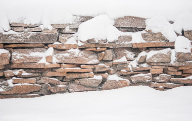 winter in village, stone fence covered by snow
