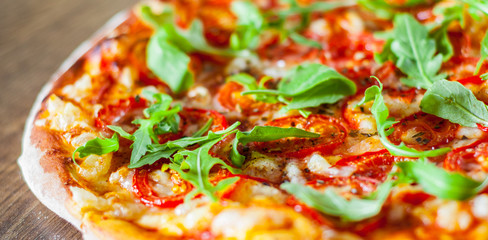 vegetarian Pizza with Mozzarella cheese, Tomatoes, pepper, Spices and Fresh arugula. Italian pizza. Pizza Margherita or Margarita on wooden table background