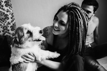 Young girl with dreadlocks holding a dog.