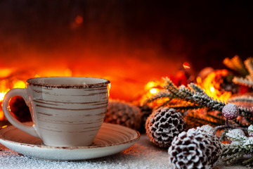 A cup of coffee stands on the background of Christmas lights