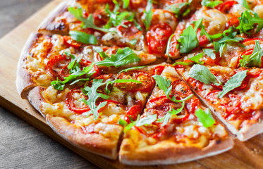 vegetarian Pizza with Mozzarella cheese, Tomatoes, pepper, Spices and Fresh arugula. Italian pizza. Pizza Margherita or Margarita on wooden table background