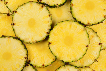 Pineapple juicy yellow slices background. Top view.