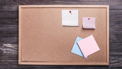 Pinned blank paper note on cork background