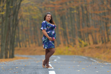 a young pregnant woman in autumn forest