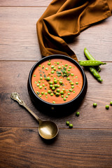 Green Peas curry / Matar masala served in a bowl over moody background. selective focus