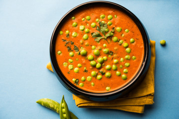Green Peas curry / Matar masala served in a bowl over moody background. selective focus