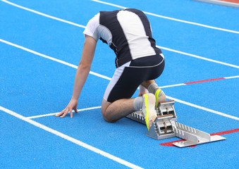 athlete in the starting blocks of a athletic track before the start