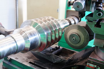 Grinding of the worm shaft on the backing machine. Industrial industry manufacturing gear shafts.