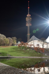 Obraz premium Munich olympic TV tower situated in Olympiapark on a clear night with heavy lensflare.