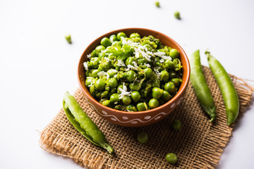Green peas dry recipe or matar ki sookhi sabji, served in a serving pan or terracotta bowl. Selective focus
